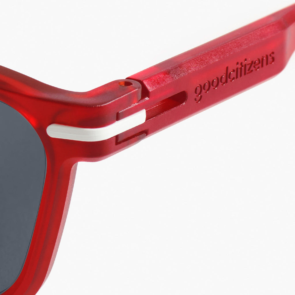 Side view close-up of red square sunglasses made in Australia, showcasing the 100% recycled frame and award-winning detail